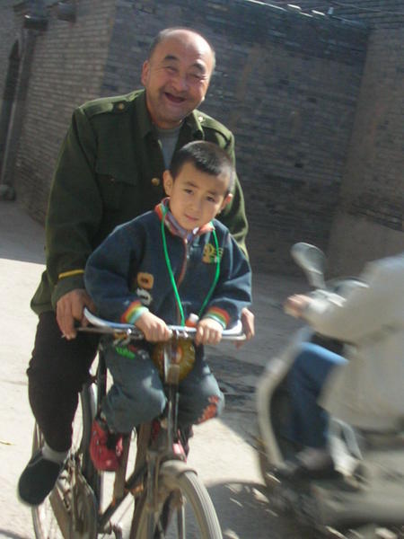 Abuelo y nieto compartiendo bicicleta