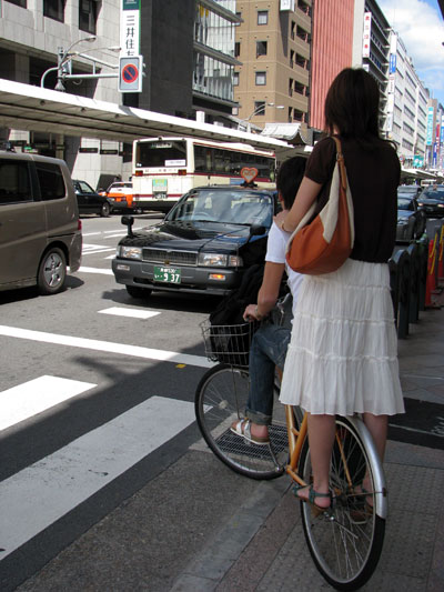 De pie sobre la rueda trasera de la bicicleta en Tokyo
